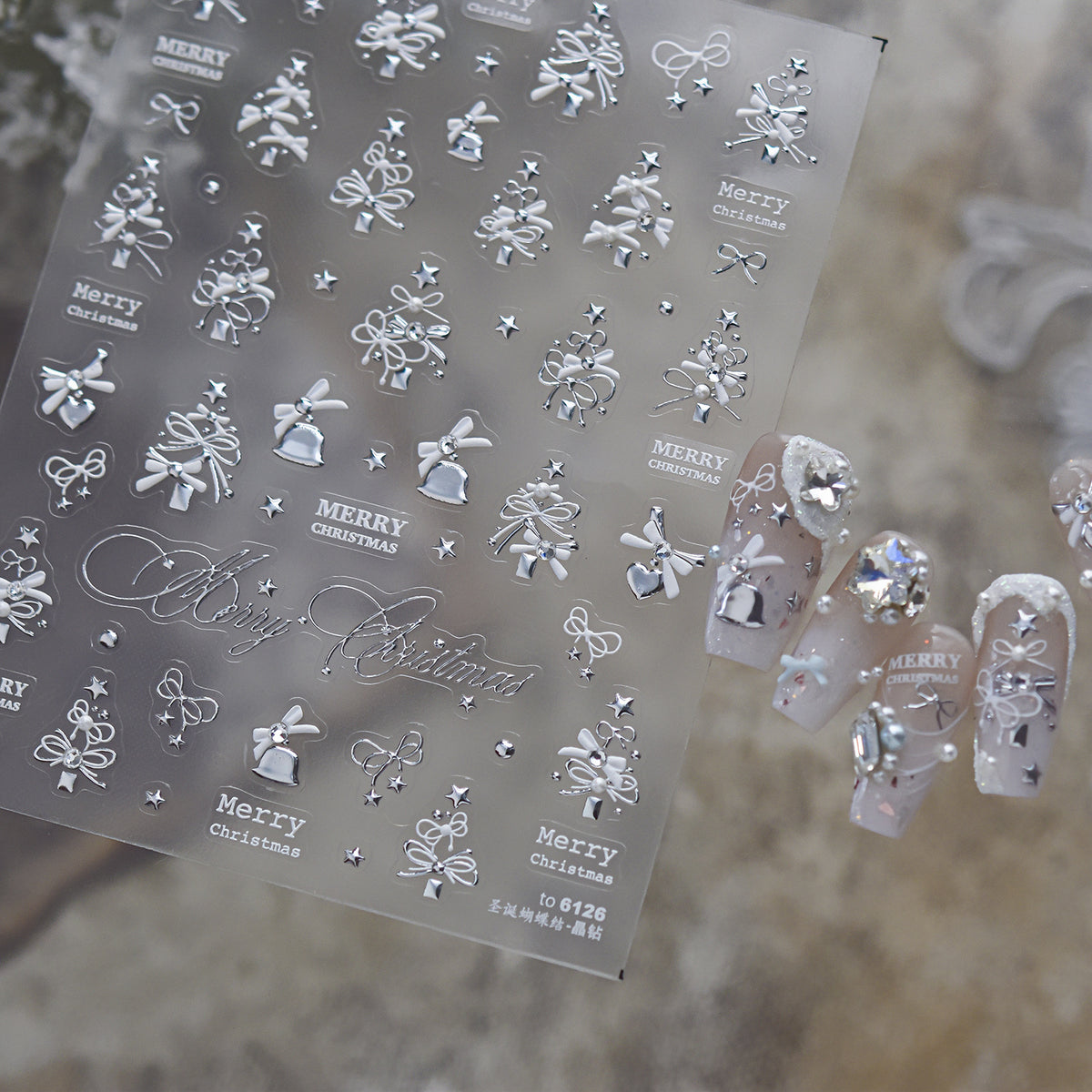  Luxury silver 3D embossed Christmas nail stickers with embedded rhinestones, featuring elegant snowflakes, bows, Christmas trees, and "Merry Christmas" text, alongside glamorous silver holiday nail art.