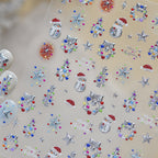 Assorted small festive 3D nail decals for Christmas, including tiny Santa hats, ornaments, stars, and snowflakes in silver and colors, designed for easy holiday nail decoration.