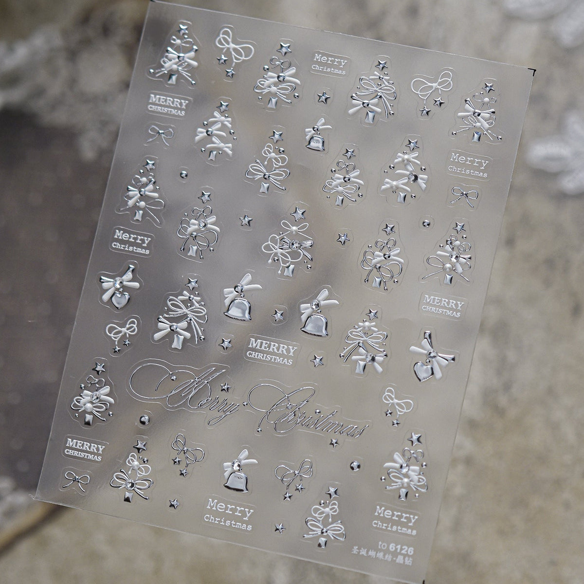 Luxury silver 3D embossed Christmas nail stickers with embedded rhinestones, featuring elegant snowflakes, bows, Christmas trees, and "Merry Christmas" text, alongside glamorous silver holiday nail art.